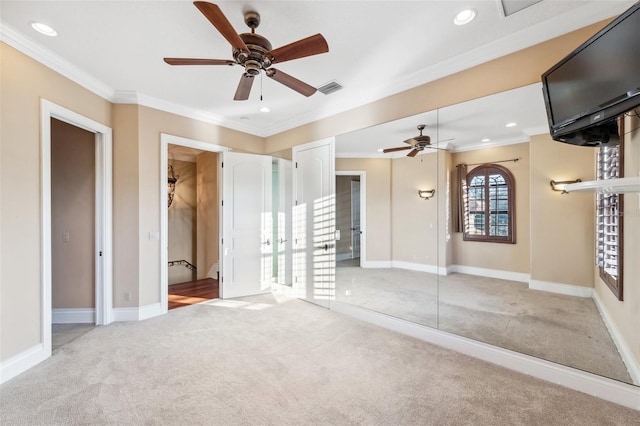 interior space with light colored carpet, ceiling fan, and crown molding