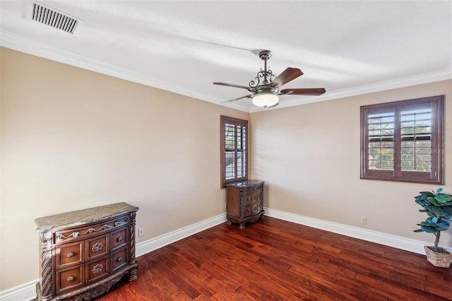 spare room with a wealth of natural light, dark hardwood / wood-style flooring, ceiling fan, and crown molding