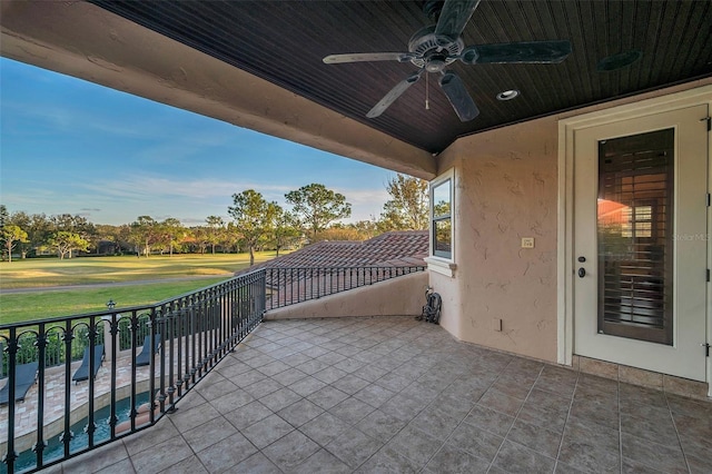 view of patio featuring ceiling fan and a balcony