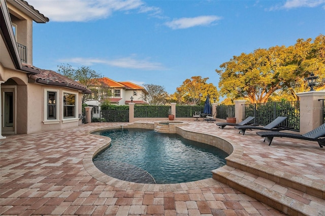 view of swimming pool featuring a patio area and an in ground hot tub