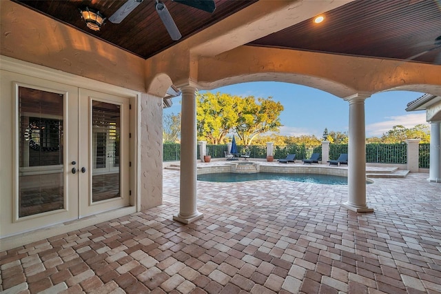 exterior space featuring a swimming pool with hot tub, ceiling fan, and french doors