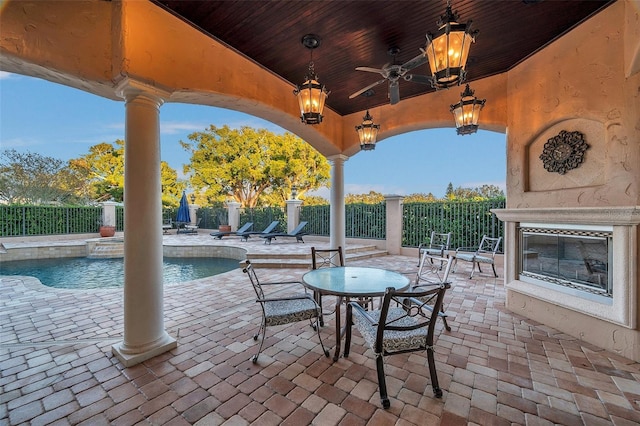 view of patio / terrace featuring a fenced in pool, ceiling fan, and exterior fireplace