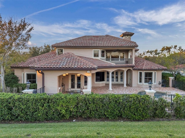 back of house featuring french doors, a balcony, and a patio area