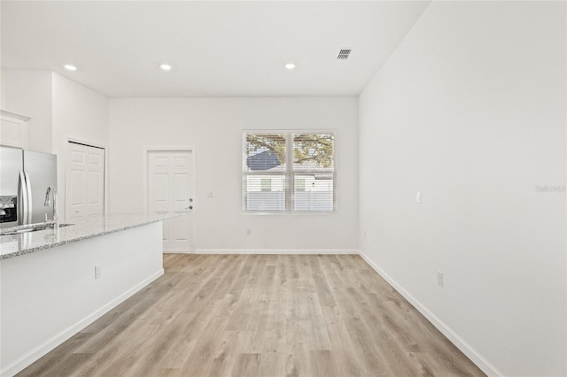 unfurnished living room with light wood-type flooring and sink