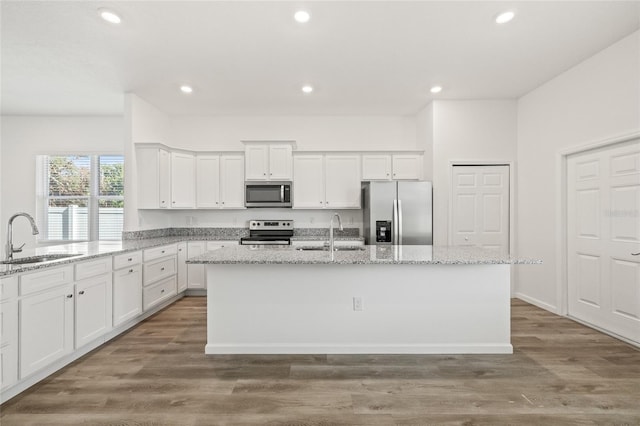 kitchen featuring dark hardwood / wood-style flooring, stainless steel appliances, a center island with sink, and sink