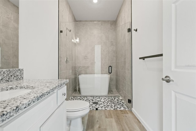 bathroom featuring hardwood / wood-style floors, vanity, toilet, and an enclosed shower