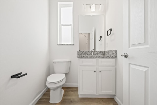 bathroom with vanity, toilet, and wood-type flooring