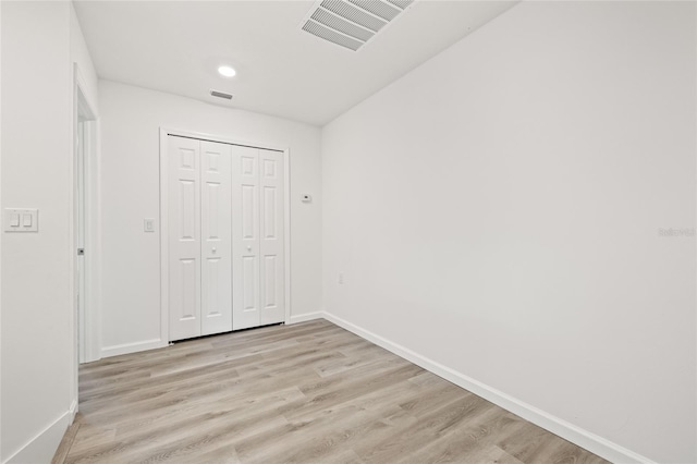 unfurnished bedroom featuring a closet and light hardwood / wood-style flooring