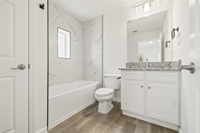 full bathroom with vanity, tiled shower / bath combo, hardwood / wood-style flooring, and toilet