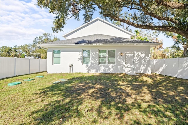 back of property featuring a lawn