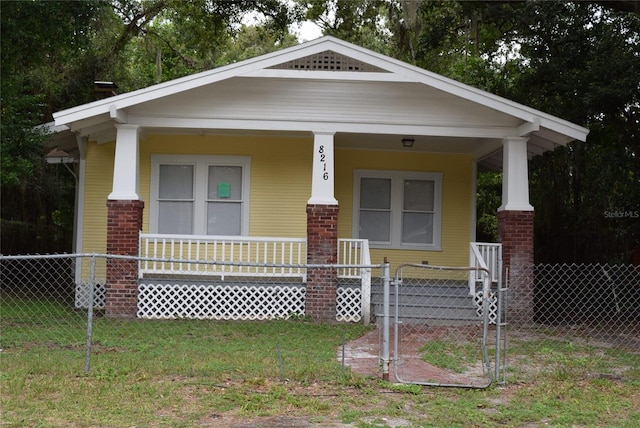 8216 N 14th St, Tampa, FL 33604 - view of front of home with covered porch, brick siding, and a gate