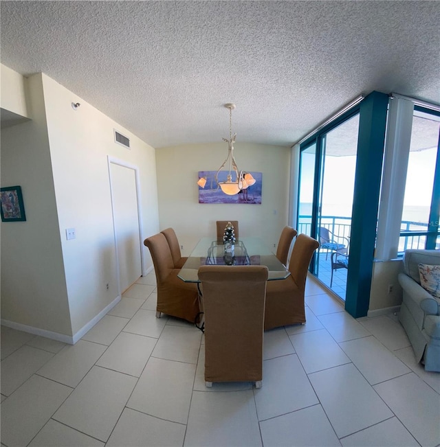 dining space with plenty of natural light, light tile patterned flooring, a wall of windows, and a textured ceiling