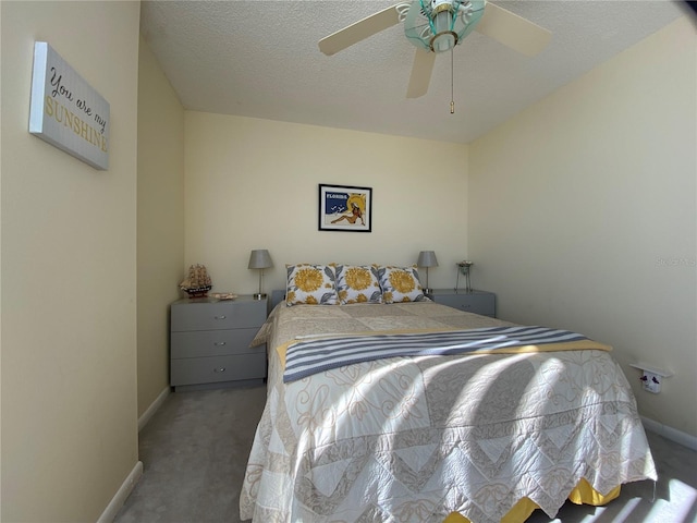 carpeted bedroom with ceiling fan and a textured ceiling