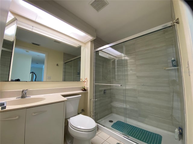 bathroom with tile patterned flooring, vanity, toilet, and walk in shower