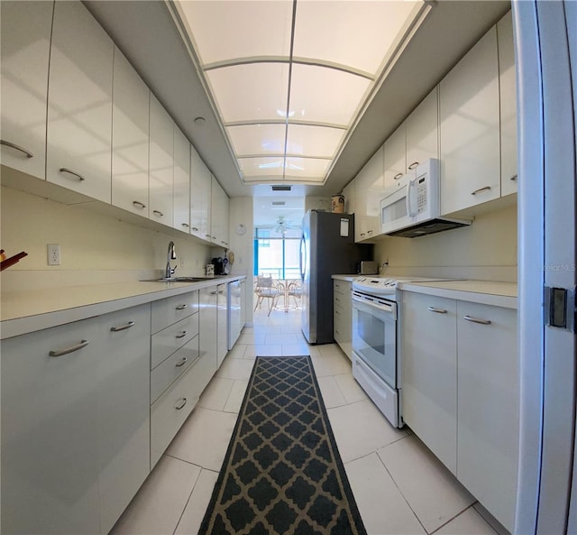 kitchen featuring white cabinets, white appliances, sink, and light tile patterned floors