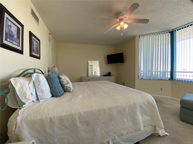 bedroom featuring carpet, ceiling fan, and a textured ceiling