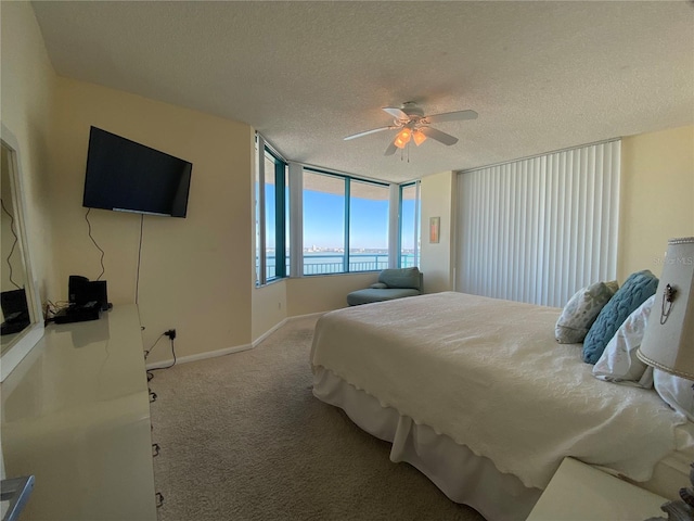 carpeted bedroom featuring ceiling fan and a textured ceiling