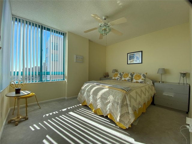 bedroom with ceiling fan, light colored carpet, and a textured ceiling