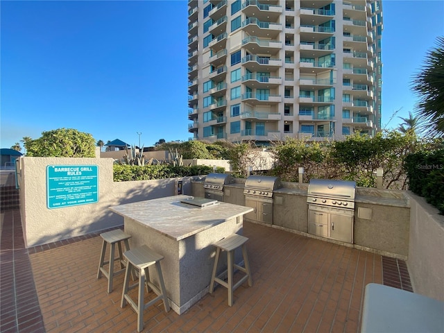 view of patio featuring exterior bar, an outdoor kitchen, and area for grilling