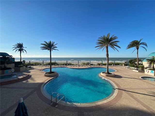 view of pool featuring a patio and a water view