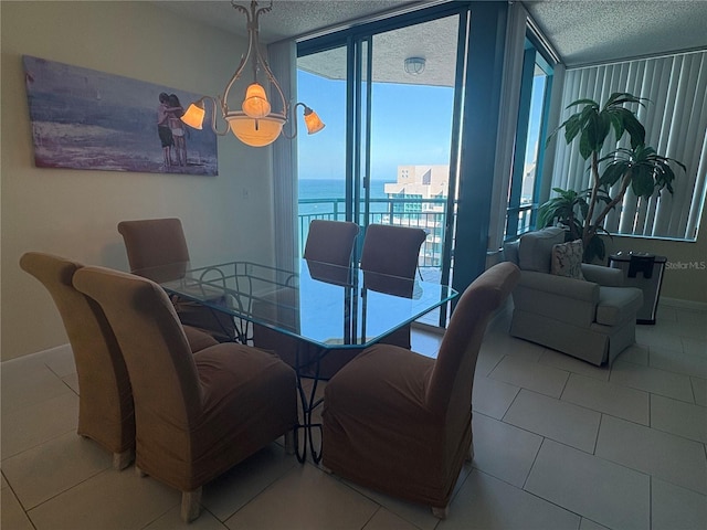 dining space with expansive windows, light tile patterned flooring, a water view, and a textured ceiling