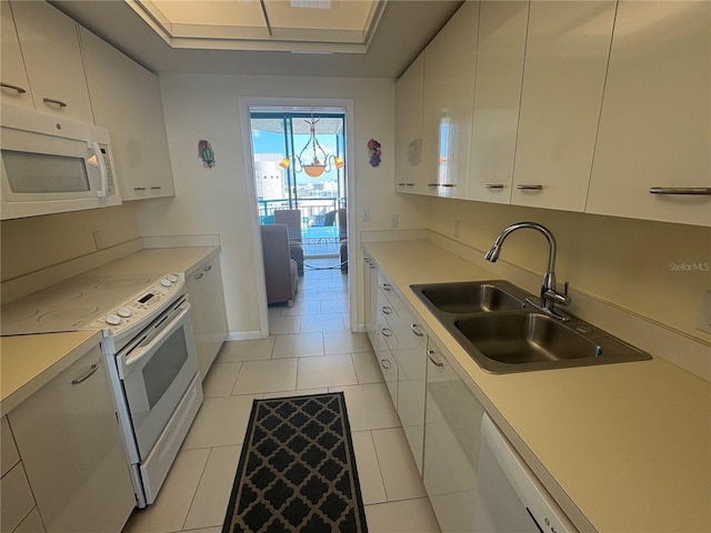 kitchen with sink, white appliances, light tile patterned floors, and white cabinets