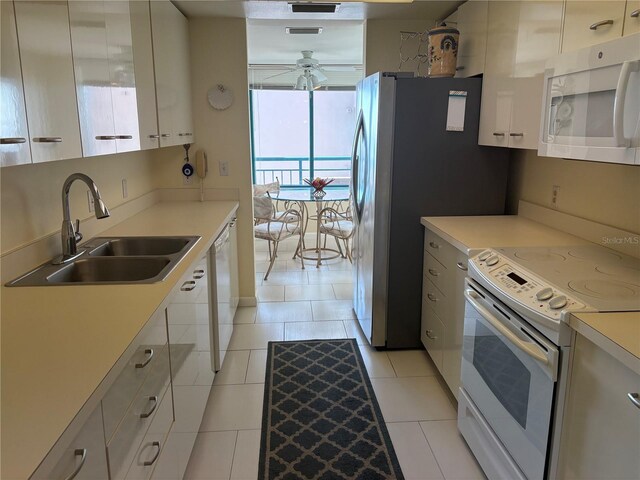 kitchen featuring sink, white cabinetry, white appliances, light tile patterned floors, and ceiling fan