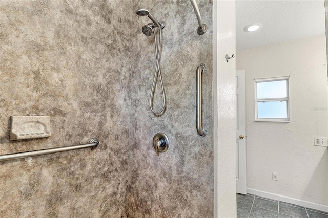 bathroom with a tile shower and tile patterned floors