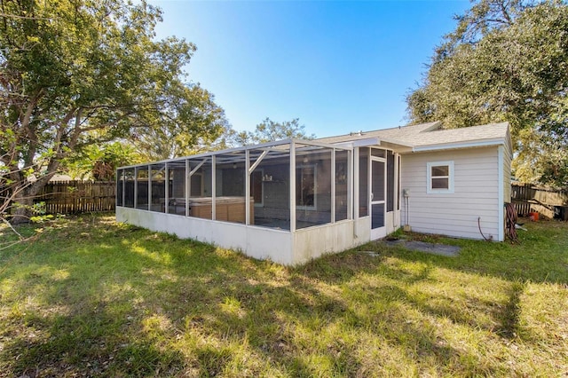 rear view of house with a lanai and a yard