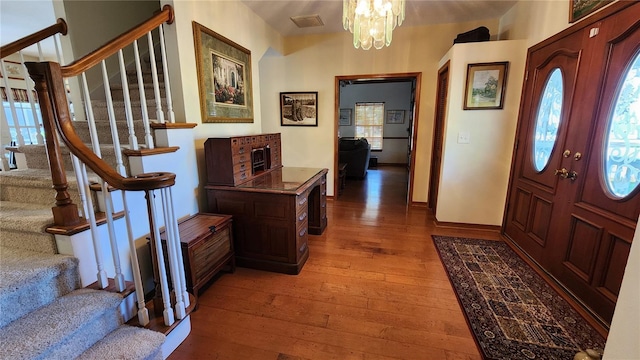 foyer featuring wood-type flooring and a chandelier