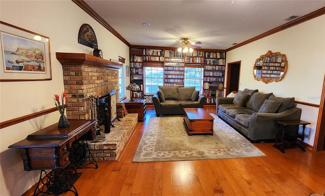 living room featuring a fireplace, hardwood / wood-style flooring, ceiling fan, and ornamental molding