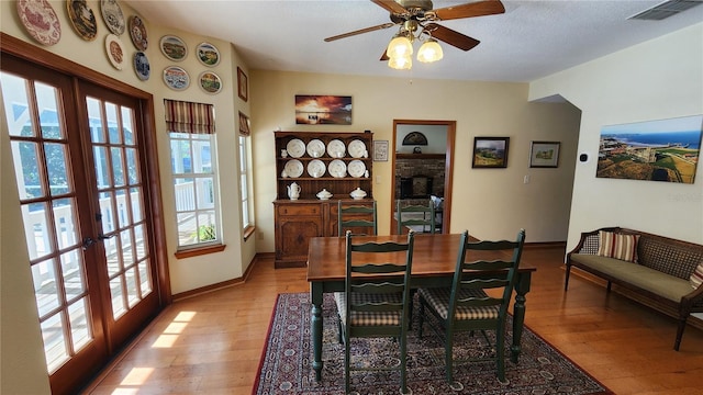 dining space with french doors, light hardwood / wood-style flooring, and a wealth of natural light