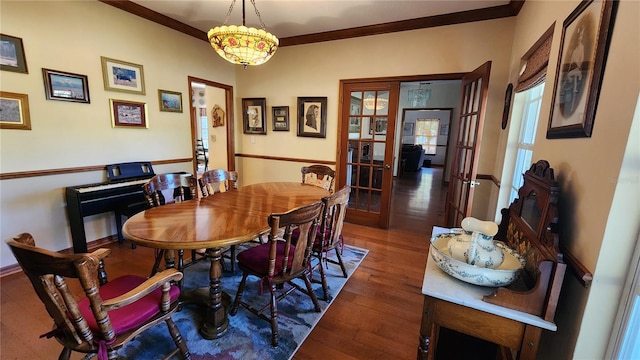 dining space featuring dark hardwood / wood-style floors, ornamental molding, and french doors