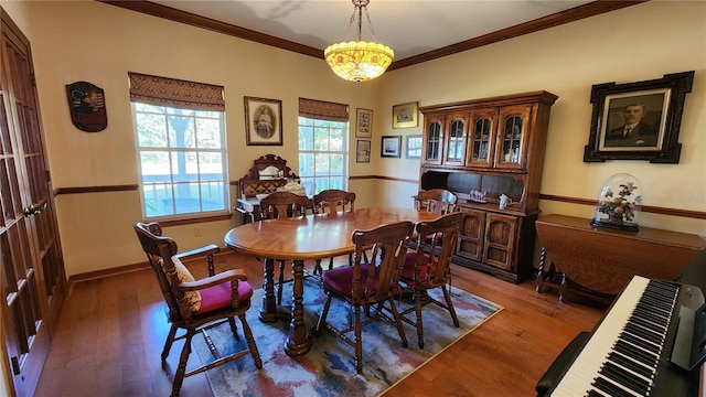 dining room with ornamental molding, dark wood-type flooring, and an inviting chandelier