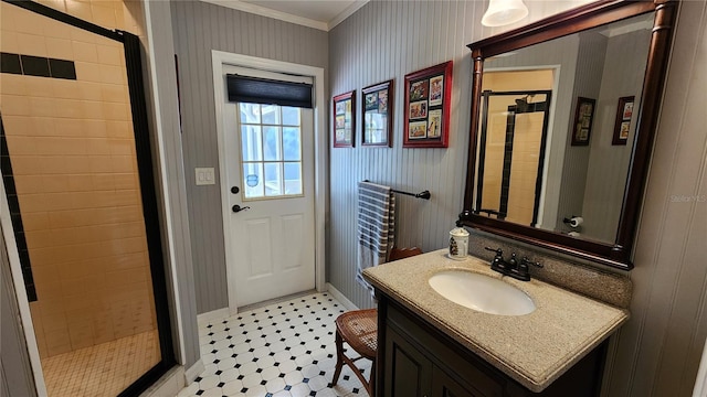 bathroom featuring vanity, ornamental molding, and tiled shower