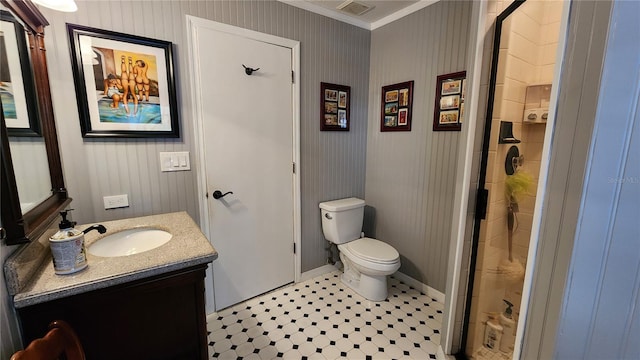 bathroom with crown molding, toilet, vanity, and walk in shower