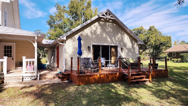 rear view of property featuring a lawn