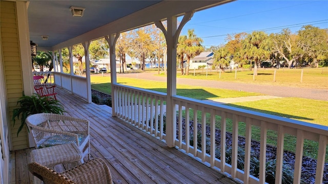 deck featuring a porch and a yard