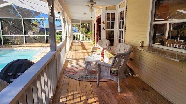 deck featuring glass enclosure, ceiling fan, and a grill