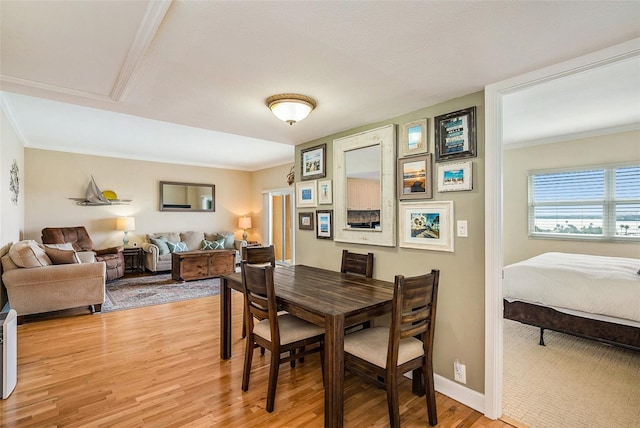 dining area with light hardwood / wood-style flooring and ornamental molding