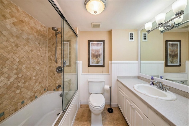 full bathroom with shower / bath combination with glass door, vanity, tile patterned floors, and toilet