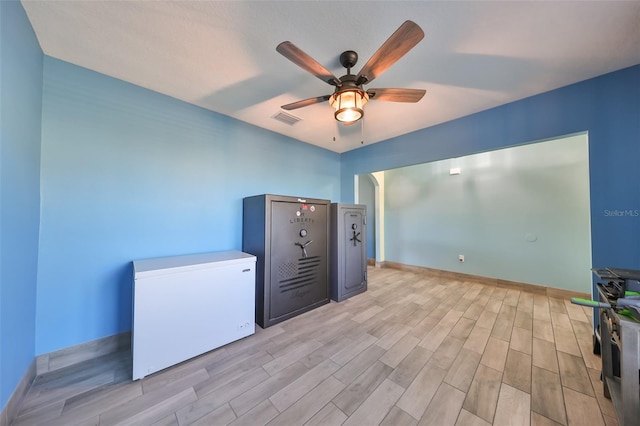 empty room with ceiling fan and light hardwood / wood-style floors