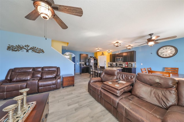 living room featuring ceiling fan and light wood-type flooring