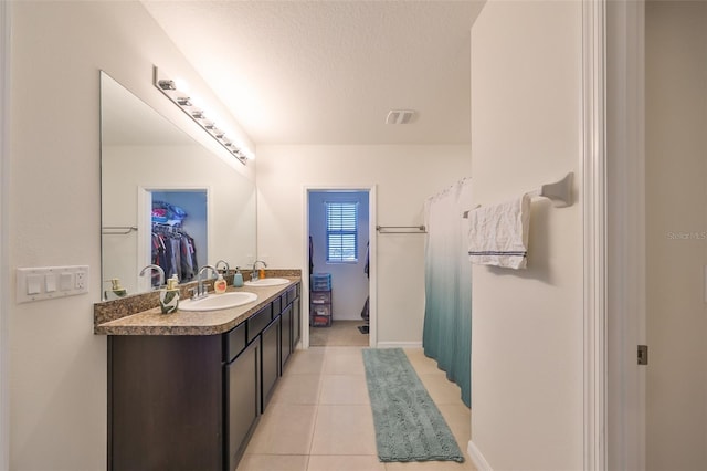 bathroom with tile patterned flooring, vanity, a textured ceiling, and a shower with shower curtain