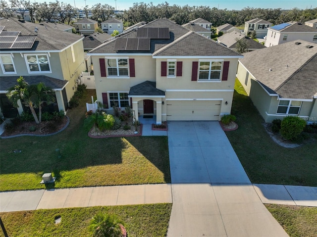 view of front of property featuring solar panels, a front lawn, and a garage