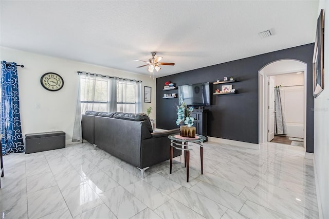 living room featuring a textured ceiling and ceiling fan