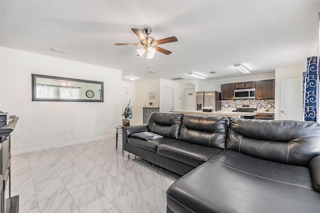 living room with ceiling fan and a textured ceiling