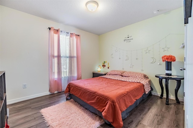 bedroom with hardwood / wood-style flooring and a textured ceiling