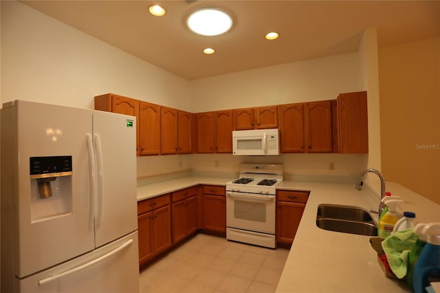 kitchen with sink, white appliances, and light tile patterned floors