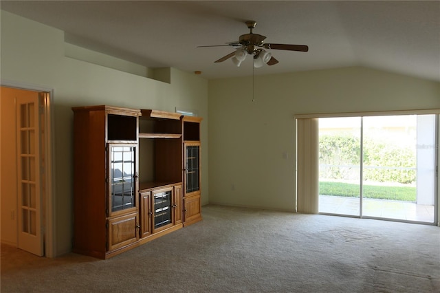 unfurnished living room with ceiling fan, carpet flooring, and vaulted ceiling